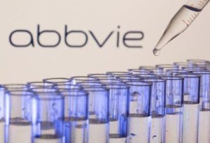 Test tubes are seen in front of a displayed Abbvie